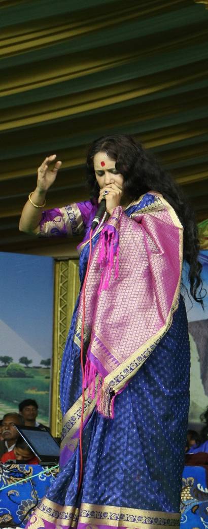 Sadhana Yogalakshmi singing during a spiritual program