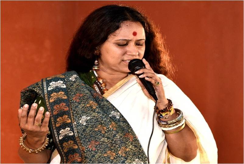 Sadhana Yogalakshmi singing with a microphone