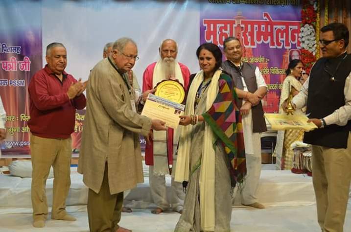 Sadhana Yogalakshmi receiving recognition on stage